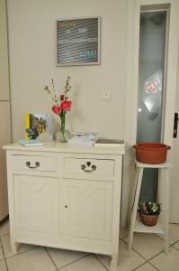 - une commode blanche avec un vase de fleurs dans l'établissement Holiday Home 't Regulierenhuisje, à Tongres