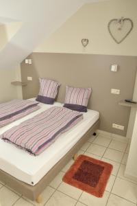 um quarto com uma cama com almofadas listradas e um tapete em Holiday Home 't Regulierenhuisje em Tongeren