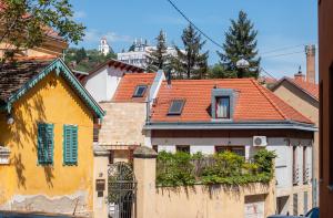 een huis met een oranje dak en een hek bij Keltaur Studio Apartman with garage in Pécs
