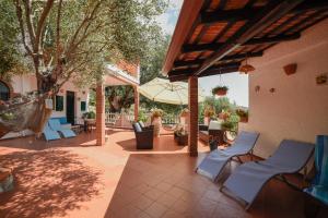 patio z niebieskimi krzesłami i parasolem w obiekcie Baia Luna w mieście Marina di Camerota