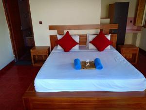 een slaapkamer met een bed met rode kussens bij Uma Kutuh Bungalow in Ubud