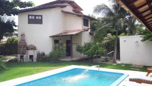 une maison avec une piscine en face d'une maison dans l'établissement Casa na linda praia de Jericoacoara, à Jericoacoara