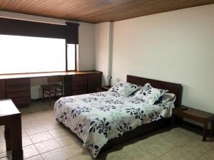 a bedroom with a bed and a window at Apartamentos Percales in Bogotá
