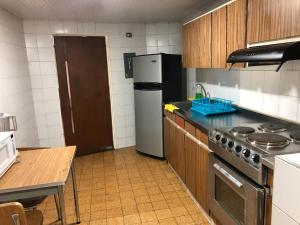 a kitchen with a stove and a refrigerator at Apartamentos Percales in Bogotá