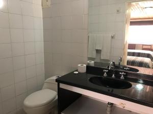 W łazience znajduje się umywalka, toaleta i lustro. w obiekcie Apartamentos Percales w mieście Bogota