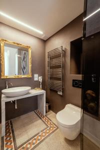 a bathroom with a toilet and a sink and a mirror at Palazzo dei Grifoni - Luxury Suites - in San Benedetto del Tronto