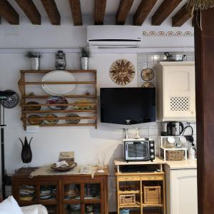 a kitchen with a microwave and a tv on a wall at La Corte in Venice