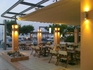 ein Restaurant mit Tischen, Stühlen und Lichtern in der Unterkunft Violetta in Kamena Vourla