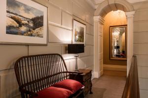 uma sala de estar com uma cadeira e um espelho em Eshott Hall em Morpeth