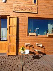 a building with two chairs and a table on a deck at Rifugio Il Ginepro dell'Etna in Linguaglossa