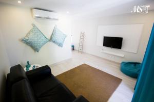 a living room with a couch and a flat screen tv at MS Apartamentos, Setúbal in Setúbal