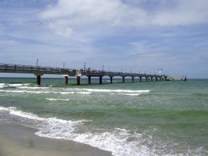 a pier in the ocean next to the beach at Ferienwohnung Kruppa Rerik in Rerik +4 photos