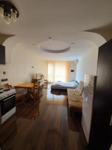 eine Küche und ein Wohnzimmer mit einem Bett und einem Tisch in der Unterkunft Apartments in Princess Residence in Baltschik