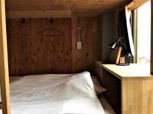 a bed in a room with a wooden wall at Hostel Bedgasm in Tokyo