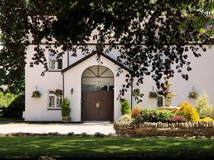 una casa bianca con una porta marrone di Llechwen Hall a Pontypridd