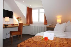 a hotel room with a bed and a chair at Altstadt-Hotel Passau in Passau