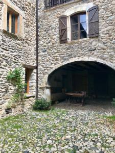 a stone building with a picnic table in front of it at Casa Mingot SXVI Anciles Benasque in Anciles