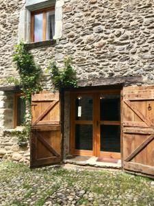 ein altes Steingebäude mit einer Holztür in der Unterkunft Casa Mingot SXVI Anciles Benasque in Anciles