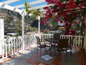 een tafel en stoelen op een balkon met bloemen bij Casa Rural Lili in Vallehermoso