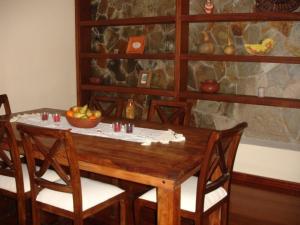 una mesa de madera con sillas y un bol de fruta. en Casa Rural Lili en Vallehermoso