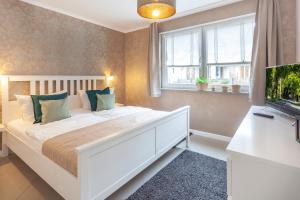 a bedroom with a large white bed and a window at Strandhaus Manatee mit Sauna und Kamin in Ostseebad Sellin