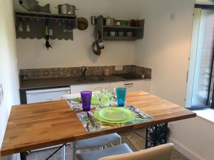 a wooden table with a plate and glasses on it at Gîte horizon mer et campagne in Pornic