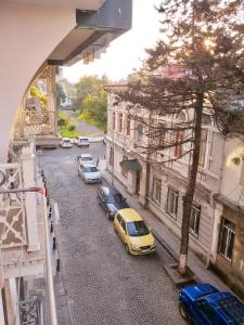 eine Gruppe von Autos, die auf einer Straße mit Gebäuden geparkt sind in der Unterkunft Boulevard apartment in Batumi