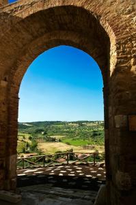 an archway in a building with a view of a field at Locanda Delle Mura Anna De Croy in Magliano in Toscana