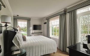 a bedroom with a large bed and a large window at Monkey Island Estate - Small Luxury Hotels of the World in Bray