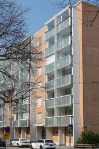 ein Mehrfamilienhaus mit davor geparkten Autos in der Unterkunft Torget Apartment Laululinna in Pori
