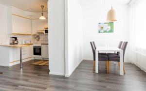eine Küche und ein Esszimmer mit Tisch und Stühlen in der Unterkunft Torget Apartment Laululinna in Pori + 2 Fotos