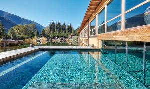 a house with a swimming pool next to a building at Arosea Life Balance Hotel in Santa Valpurga