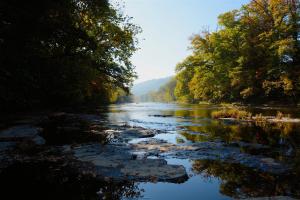 a river with trees and reflections in the water at Snug Oak Hut with a view on a Welsh Hill Farm in Brecon +18 photos