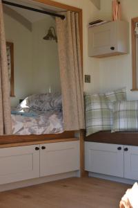 um quarto com uma cama e um espelho em Snug Oak Hut with a view on a Welsh Hill Farm em Brecon