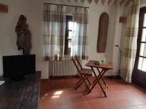 ein Wohnzimmer mit Fernseher und Holztisch in der Unterkunft Agriturismo La Verena in Vesime