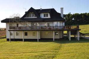 een huis met een terras op een veld bij Hotelik Dworek in Legnickie Pole