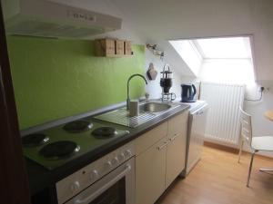 a green kitchen with a sink and a stove at Weingut Arnold Pauly in Osann-Monzel