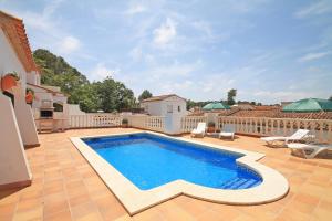 a swimming pool on a patio with a house at Holiday Home Olivia in L'Escala