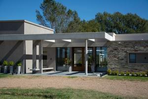 une maison avec un bâtiment en pierre et une terrasse couverte dans l'établissement Portal del Callvú, à Azul