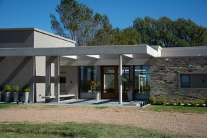 uma casa com um edifício de pedra com um alpendre em Portal del Callvú em Azul