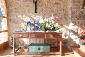 une table en bois avec des fleurs au-dessus d'un mur en pierre dans l'établissement Can Mas Albanyà, à Albanya