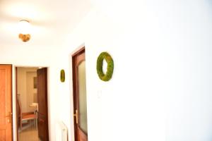 korytarz z drzwiami i wieniec na ścianie w obiekcie FLH - Emma Apartment w Sybinie
