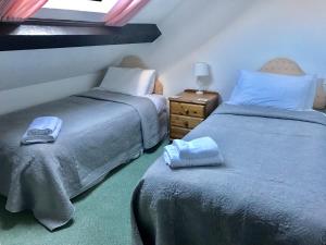 um quarto com 2 camas, uma mesa de cabeceira e uma janela em Linhay -Farm Cottage em Sidmouth