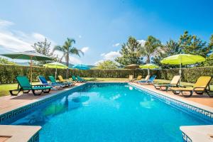 - une piscine avec des chaises longues et des parasols dans l'établissement Nave Redonda do Cerro – Countryside & Nature, à Nave Redonda