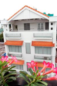 a white building with red roofs and pink flowers at LeBlanc Saigon in Ho Chi Minh City