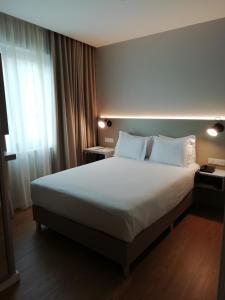 a bedroom with a large bed and a window at ClipHotel in Vila Nova de Gaia