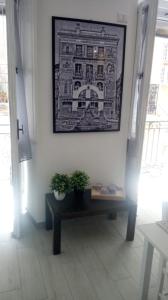 um quarto com um banco e uma fotografia na parede em casa nonna Emma em Iglesias