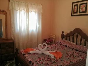 a bed with two towels in the shape of a heart at Casa y Departamentos Valle del Bermejo in Villa Unión