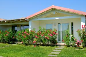 una casa con flores rosas en el patio en Hotel Budoni Beach en Budoni