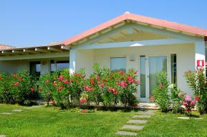 a house with pink flowers in the yard at Hotel Budoni Beach in Budoni